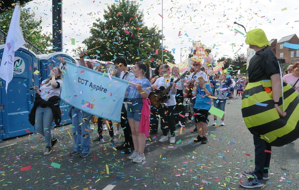 BCT Aspire young people parading with their banner at the Stockton International Riverside Festival
